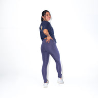 Woman in FLOWER POCKET high waisted leggings GUGA showing three-quarter angle, highlighting the feminine floral print in navy base and practical pocket placement